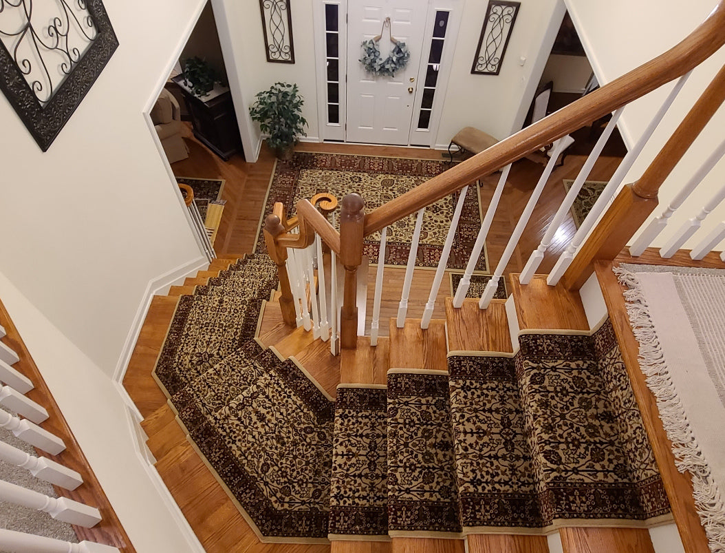Wooden staircase with patterned carpeting in a home interior.